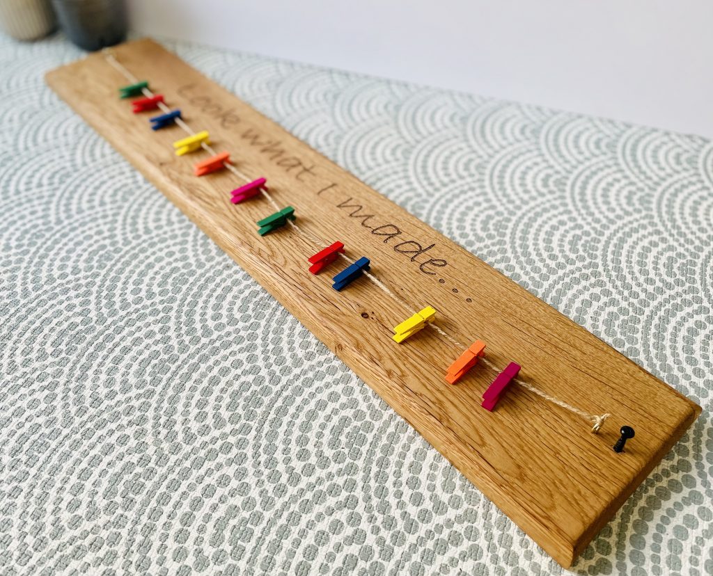 A hook created to hold up hand painted children's drawings on clips