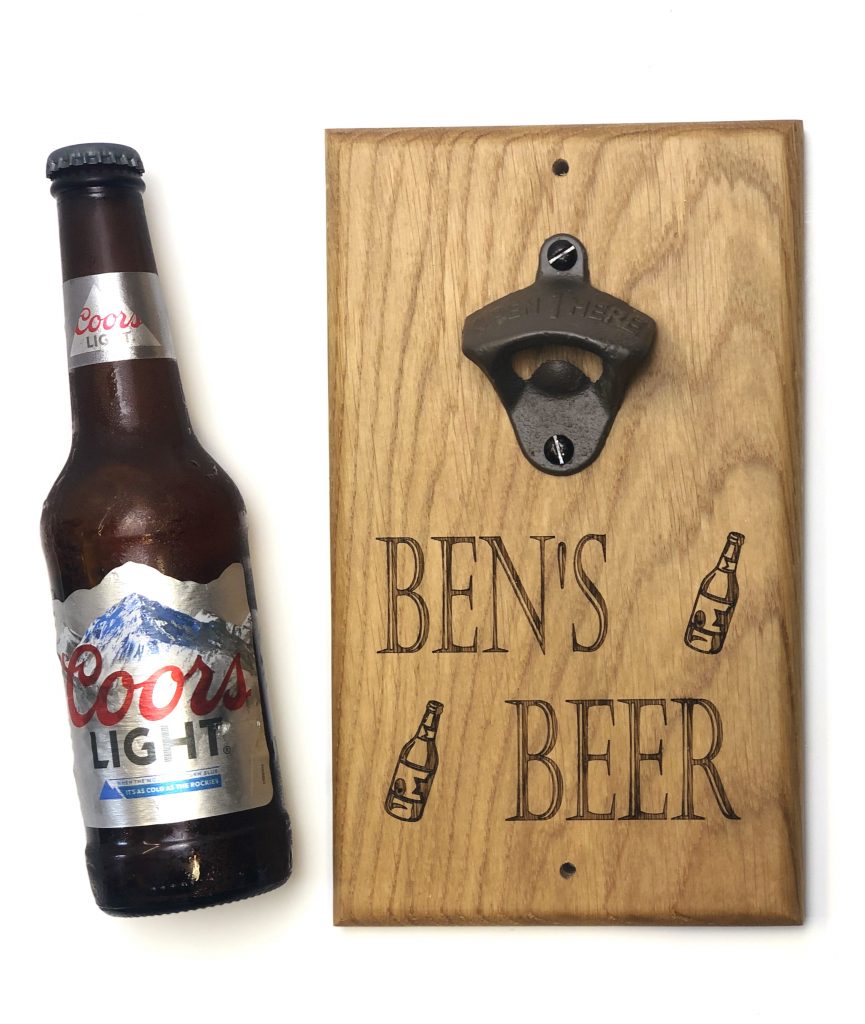 Bottle of Coors Light next to a personalised bottle opener with the words 'Ben's Beer' engraved on some kiln dried oak