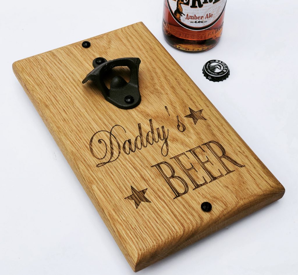 A wooden bottle opener with the words 'daddy's beer' engraved on kiln dried oak