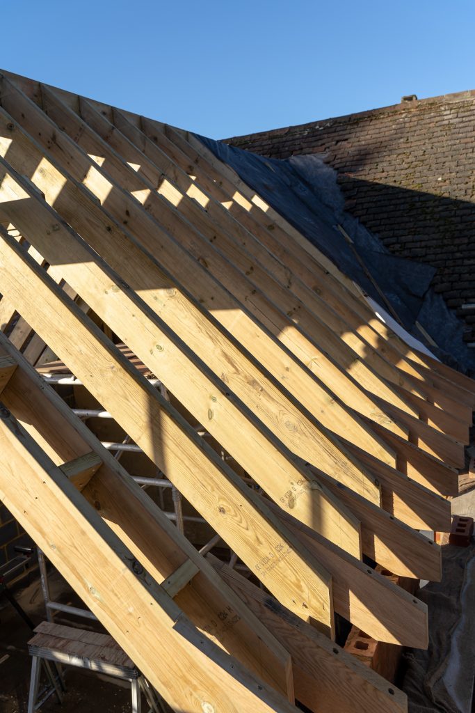 A photo showing the roofing created for the rear extension and garage using structural green oak beams from uk timber